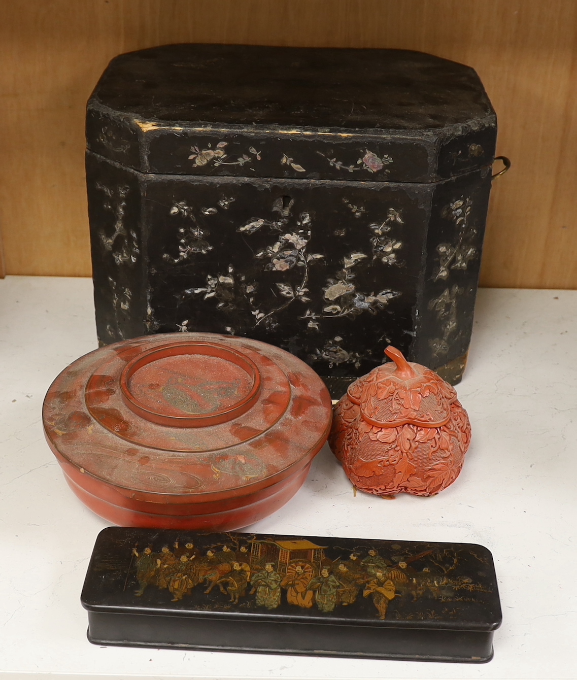 A Chinese black lacquer and mother of pearl box, two red lacquer boxes and a Chinoiserie painted box, largest 28cm wide, 37cm high